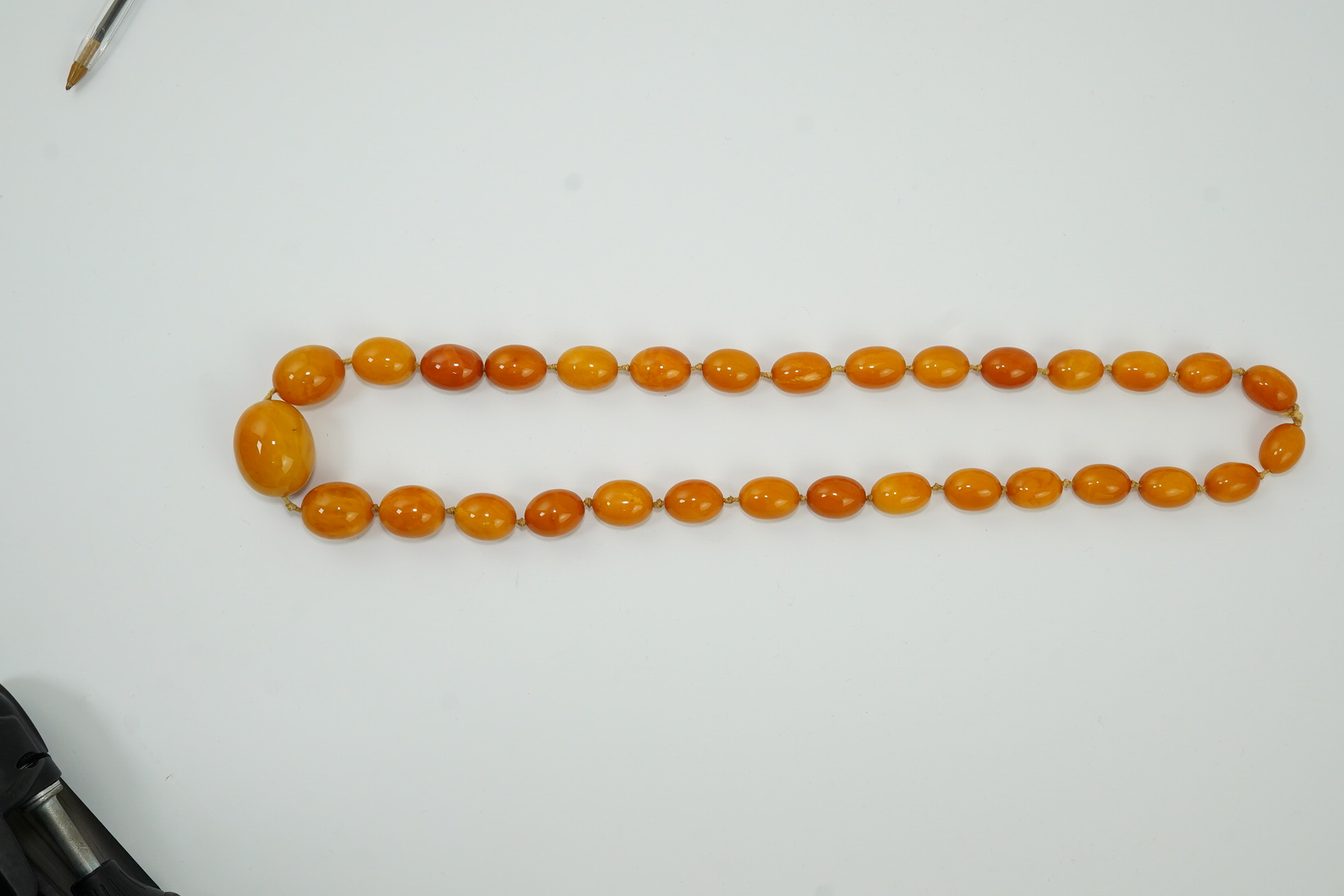 A single strand graduated oval amber bead necklace